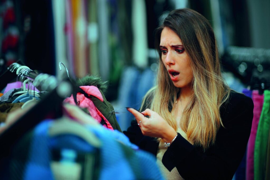 Retail customer shocked by clothing price and quality while shopping in a fashion store